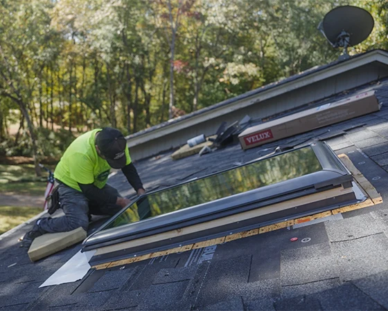 Man Installing New Skylights On Roof Of House
